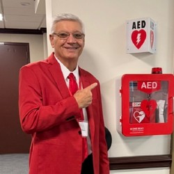 Ernie Winters pointing at an AED